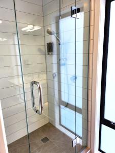 y baño con ducha y puerta de cristal. en U Suites on Rongotai Rd en Wellington