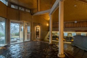 une piscine intérieure dans une maison avec une grande chambre dans l'établissement Hotel Symphony Annex Sagae Onsen, à Sagae