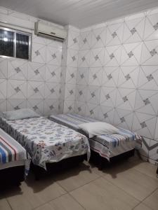 um quarto com 2 camas individuais e uma parede com em Pousada Trilha do Pelo em Salvador