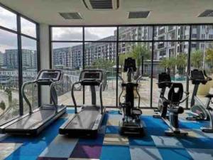 a gym with cardio machines and a large window at Radia Residence Bukit Jelutong, Shah Alam in Shah Alam