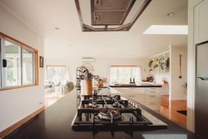 a kitchen with a stove top oven sitting under a ceiling at Paradise Valley Lodge in Rotorua