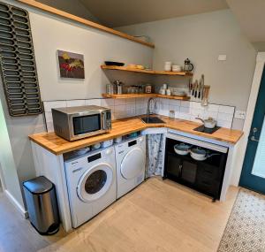 a kitchen with a microwave and a washing machine at Carriage House in Livingston