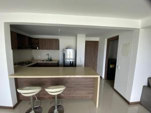 a kitchen with a counter and two bar stools at Apartamento Valle de Lili in Cali