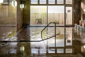 una piscina de agua en una habitación con puerta de cristal en Hotel Symphony Sagae Onsen, en Sagae