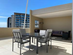 a black table and chairs on a balcony at Redvue Holiday Apartments in Redcliffe