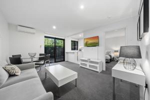 sala de estar con sofá y mesa en Manuka Park Serviced Apartments, en Canberra
