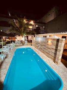 una piscina en un hotel por la noche en Flamingo Beach Pousada en Cabo Frío