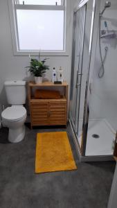 a bathroom with a toilet and a shower and a rug at River and Ridge Getaway in Turangi +12 photos