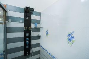 La salle de bains est pourvue d'un mur rayé noir et blanc. dans l'établissement Parudeesa - Kerala, à Kāladi