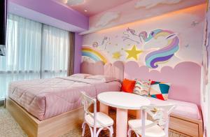 um quarto com uma cama com um arco-íris e uma mesa em Four Points by Sheraton Surabaya, Pakuwon Indah em Surabaia