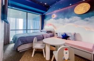 a bedroom with a bed and a table and a sky at Four Points by Sheraton Surabaya, Pakuwon Indah in Surabaya
