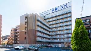 Un edificio con coches aparcados en un estacionamiento. en Toyoko Inn Kawaguchi Ekimae, en Kawaguchi