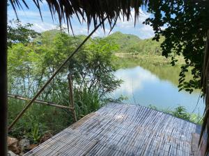 a view of a river from a wooden dock at Royal mountain Hut in Ratchaburi