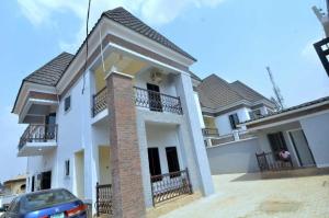uma casa branca com um carro estacionado em frente dela em Delad Hotel and Suites em Ibadan