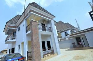 a white house with a car parked in front of it at Delad Hotel and Suites in Ibadan