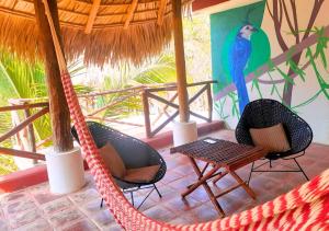 a hammock in a resort with a blue bird on the wall at Casa Andivi, Placer sin fin in San Pedro Pochutla