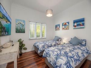 een slaapkamer met 2 bedden en een bureau bij 15 Seaview Terrace Moffat Beach QLD in Caloundra