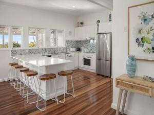 een keuken met witte kasten en een wit aanrecht bij 15 Seaview Terrace Moffat Beach QLD in Caloundra