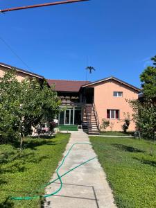 ein Gebäude mit einem grünen Schlauch auf dem Rasen in der Unterkunft Vila Baciu in Tuzla