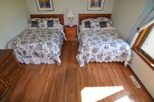 1 dormitorio con 2 camas y suelo de madera en Carraig Nua House, en Fish Creek