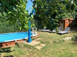 a swimming pool in a yard with chairs and a tree at cabane bambou in Huriel