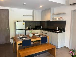 a kitchen with a wooden table and blue chairs at Deluna 23degree by The valley khao yai in Pak Chong