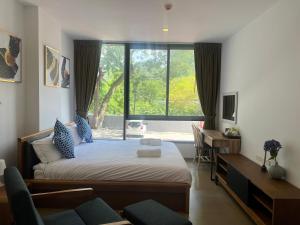 a bedroom with a bed and a desk and a window at Deluna 23degree by The valley khao yai in Pak Chong