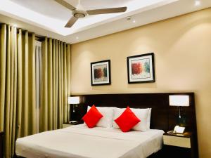 a hotel room with a bed with red pillows at Tropic Inn - Mount Lavinia in Watumulla