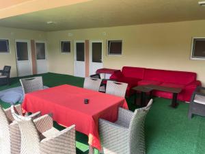 ein Wohnzimmer mit einem roten Tisch und Stühlen in der Unterkunft Vila Baciu in Tuzla