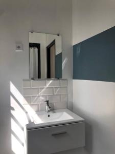 een witte badkamer met een wastafel en een spiegel bij Studio Armorique - commerces in Brest