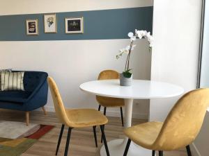 a dining room with a white table and chairs at Studio Armorique - commerces in Brest