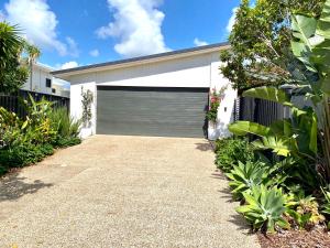 un garage con una porta grigia per garage su una casa di Casuarina Beach 4 bedroom home a Casuarina
