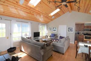 ein Wohnzimmer mit 2 Sofas und einem TV in der Unterkunft Carraig Dale Cottage in Fish Creek