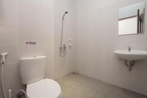 a bathroom with a toilet and a sink at Urbanview Hotel Max Living Cengkareng in Jakarta