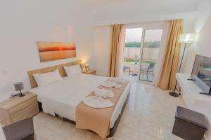 1 dormitorio con 1 cama blanca grande y TV en Viva Tourismo Resort (naturist club) en Paradeísion