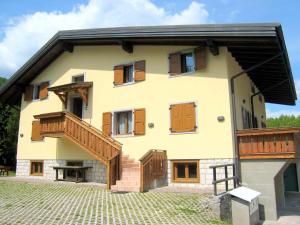 een huis met houten deuren en een balkon bij Scenic Holiday Home in Ledro near Spiggia Besta Lido in Ledro