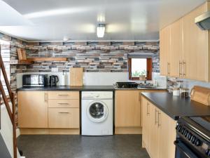 a kitchen with a washer and dryer at The Hobbit in Inverallochy