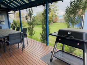 a grill on a deck with a table and chairs at Blue Tides Accommodation in Esperance