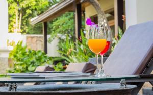 un vaso de zumo de naranja sentado en una mesa en 6BR Rawai Seaside Villa Swimming Pool en Ban Saiyuan (1)