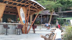 a man standing in front of a bar with a cat at Riddim Garden in Ko Samed