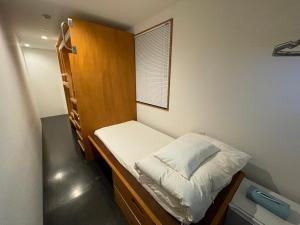 東京にあるプラット ホステル 京急 浅草カリンの小さなベッドと二段ベッドが備わる小さな客室です。