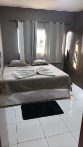 坦加拉達塞拉的住宿－Tangará da Serra，卧室设有床和窗户,铺有白色地板。