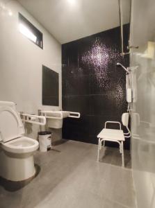 a bathroom with a toilet and a shower and a stool at Paknap Hostel in Nan
