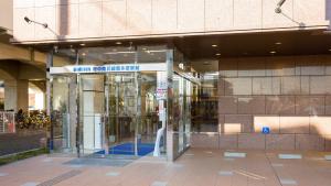 稲城市にある東横INN府中南武線南多摩駅前の回転ガラスの扉付きの建物の入口 +37枚の写真