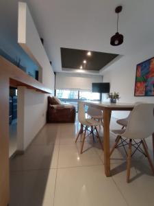 a living room with a dining room table and chairs at Departamentos Kairos H in Mendoza
