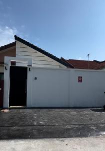um edifício branco com uma garagem com uma porta em Angsamas Villa Seremban Kids Private Pool & Jacuzzi em Seremban