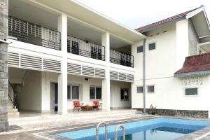 un edificio con piscina frente a él en Urbanview Wisma Nirwana Tretes by RedDoorz en Pasuruan