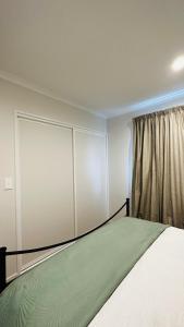 a bedroom with a bed and a window at Stay with the Singhs in Rolleston