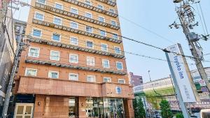 a tall building in the middle of a city at Toyoko Inn Osaka Nippombashi Bunraku Gekijo Mae in Osaka +37 photos