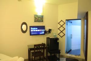 sala de estar con TV y mesa en Le Clarisse Guest House en Pondicherry